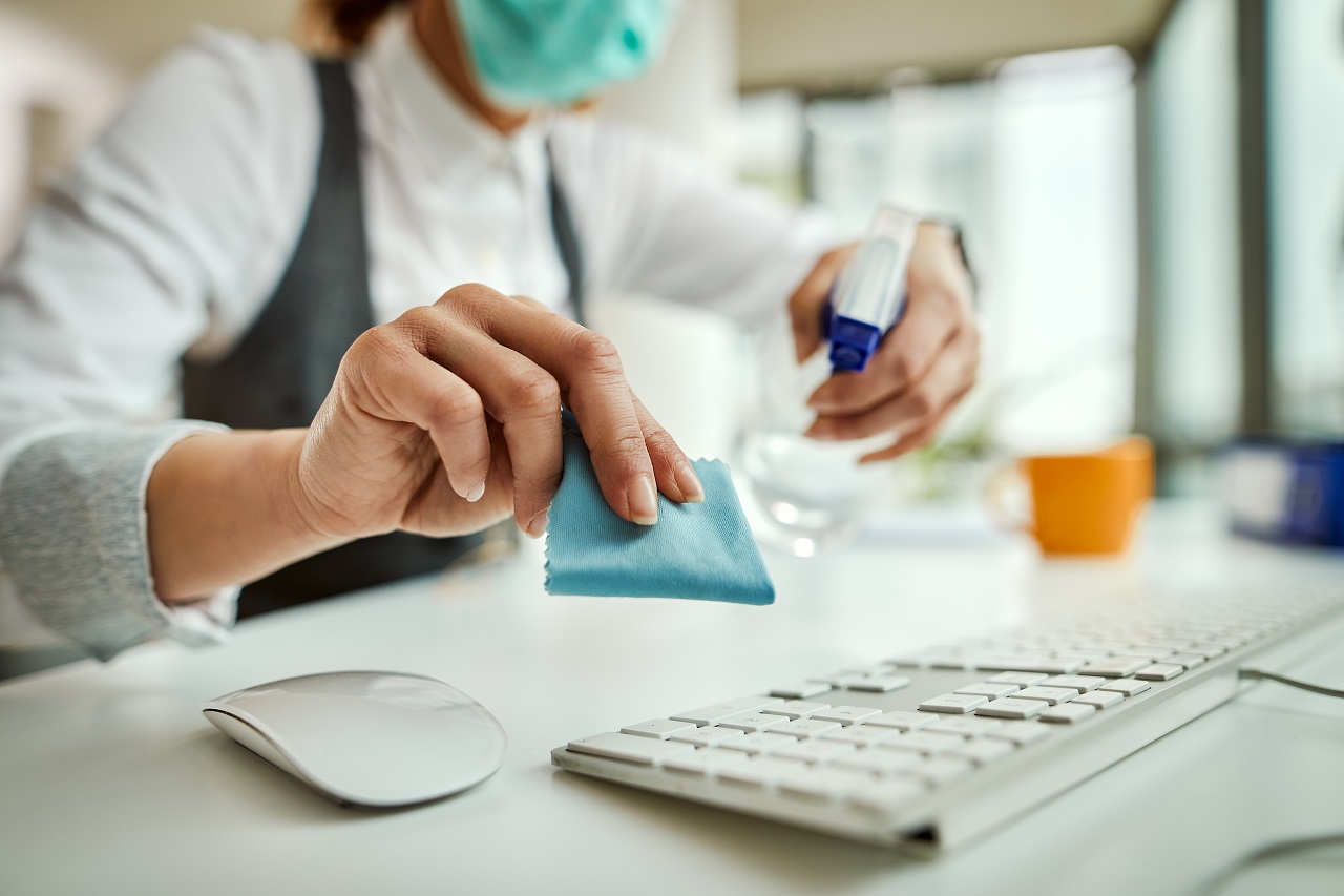 Close-up of businesswoman cleaning her computer keyboard in the office.